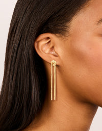 Crafted from gold plated material, these statement fringe knot earrings on ear view - link has visual effect only