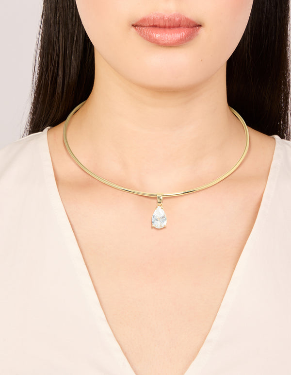 Showcasing a gold plated torque necklace with cubic zirconia teardrop pendant in dainty statement style on neck view