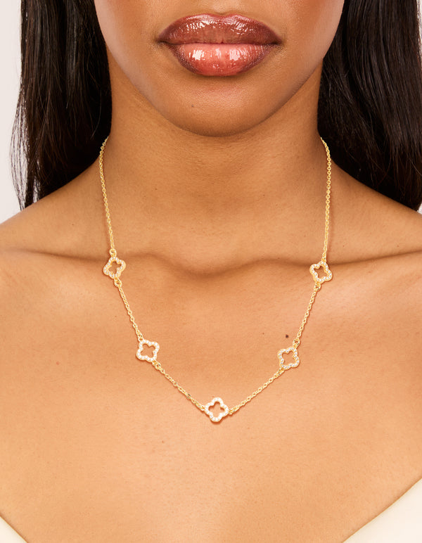 Showcasing a gold plated necklace with cubic zirconia flower charm on neck view
