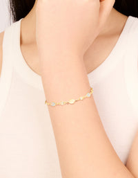 Beautifully showcasing a gold plated blue and beige oval cubic zirconia toggle bracelet on wrist view - link has visual effect only