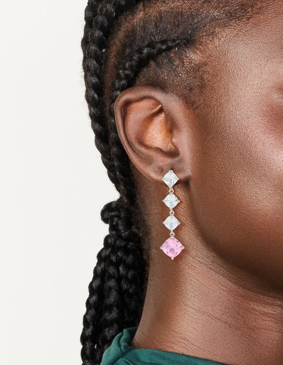 Showcasing silver pink cubic zirconia rhombus drop earrings with clear stones in a linear design on ear view