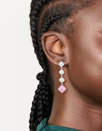 Showcasing silver pink cubic zirconia rhombus drop earrings with clear stones in a linear design on ear view - link has visual effect only