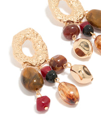 Crafted with irregular beaded drops, these earrings showcase charm details and statement design in gold close up view - link has visual effect only