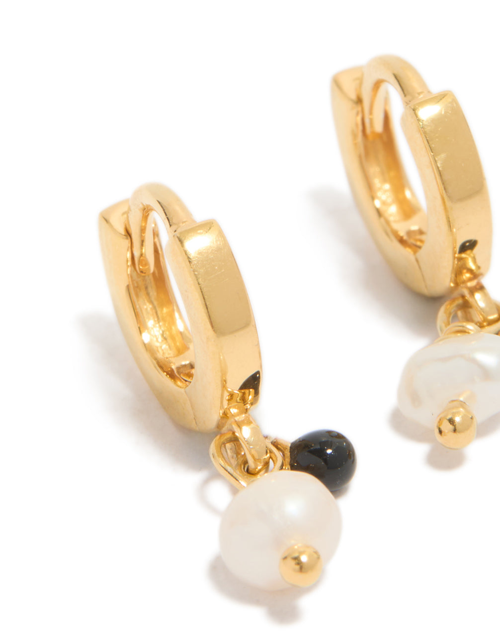 Displaying gold plated sterling silver and pearl drop huggie earrings in ivory and black close up view