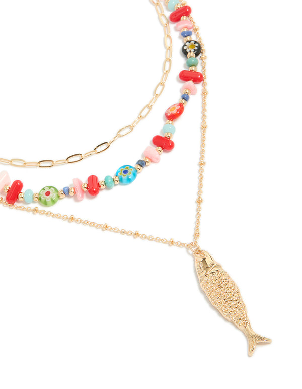 Showcasing a gold fish pendant and multicoloured beaded layered necklace with floral and ocean features in statement design close up view