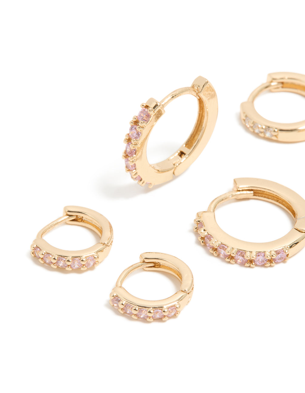 Featuring a 3-pack of gold earrings with light pink cubic zirconia and huggie closure close up view