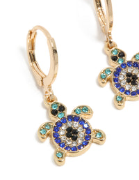 Detailed view of gold blue diamante turtle huggie earrings with turquoise and black ocean-inspired design in a close up view - link has visual effect only