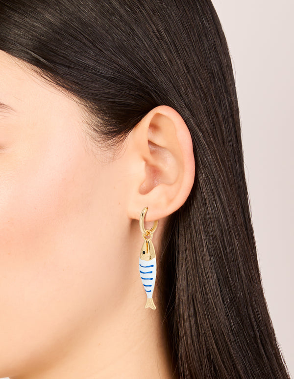 Showcasing statement huggie earrings with animal fish charm in striped pattern and ocean theme on ear view