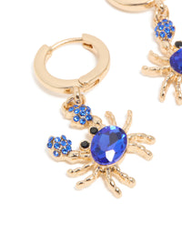 Showcasing gold dark blue diamante crab earrings with huggie closure and ocean inspired design close up view - link has visual effect only