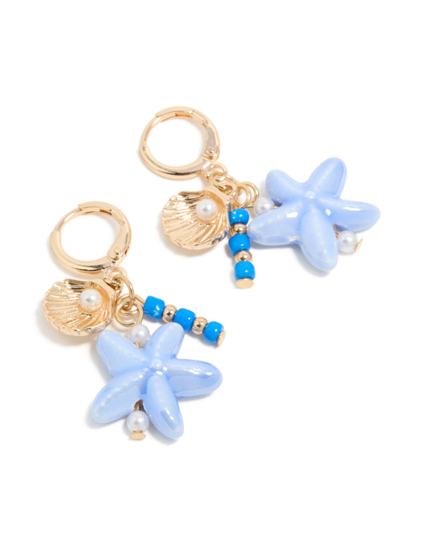 Discover gold sea life charm huggie earrings featuring ocean-inspired shell and beaded starfish accents with pearls in a front view