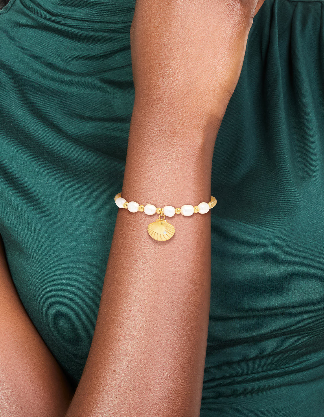 Featuring a waterproof gold plated stainless steel freshwater pearl and shell, ball bracelet with beads, ocean accents, and statement styling on wrist view