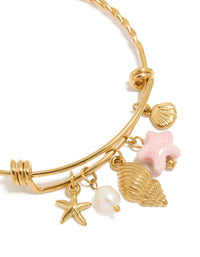 Showcasing waterproof gold plated stainless steel adjustable bangle with starfish charm, shell, ocean and pearl accents close up view - link has visual effect only