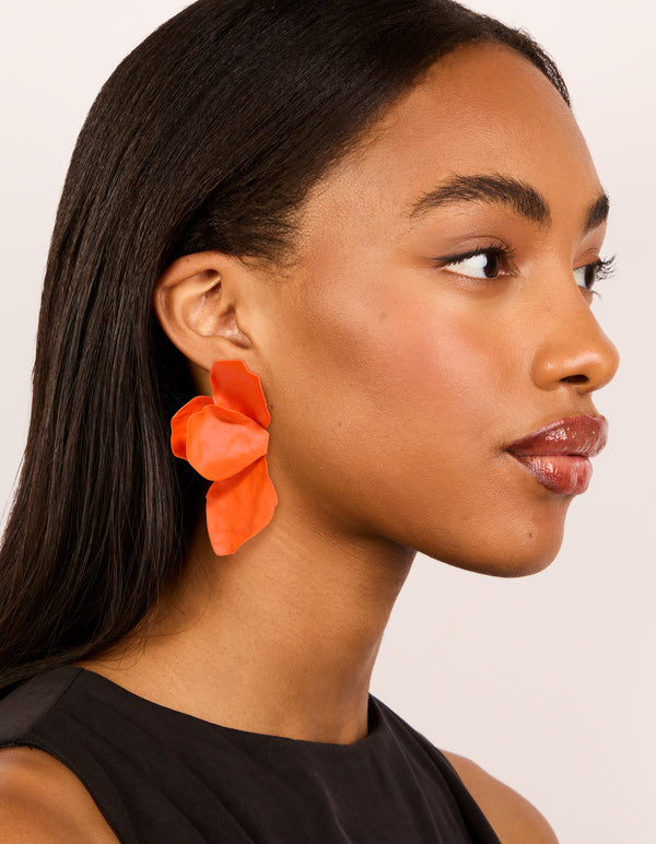 Featuring orange coated metal flower petal drop earrings with floral design in on model view
