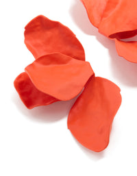 Highlighting orange coated metal flower petal drop earrings with floral design in close up view - link has visual effect only