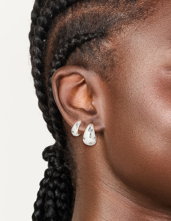 Featuring silver plated bubble huggie earrings with huggie closure in a 2-pack on ear view