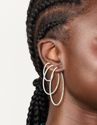 Showcasing silver plated plain hoop earrings in a 3-pack on ear view - link has visual effect only