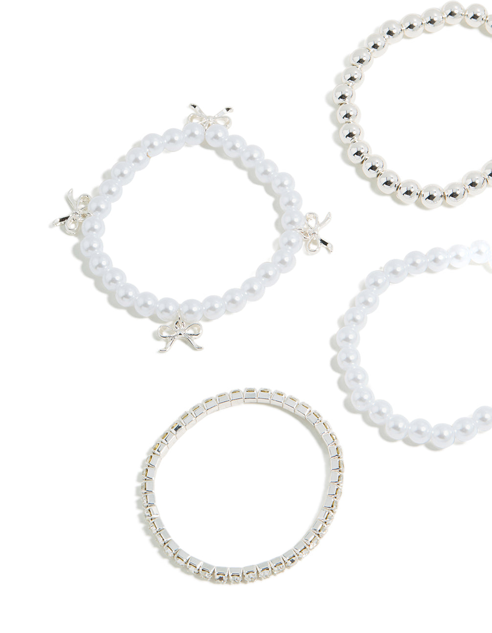 Detailed view of kids beaded stretch bracelets with bow charm accents and pearl elements in silver tones close up view