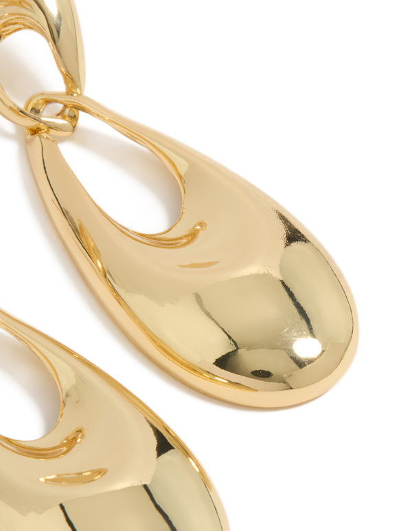 These elongated oval drop earrings in gold plated material reveal polished surface and reflective finish close up view