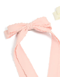 Featuring a 2-pack of fabric bow clips with scalloped edges in solid light pink and ivory detail view - link has visual effect only