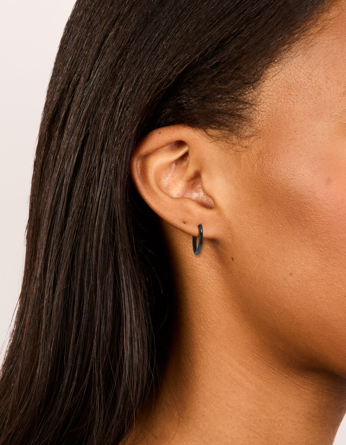 Featuring chunky waterproof black coated metal stainless steel clicker earrings with hoop closure in 14 MM on ear view