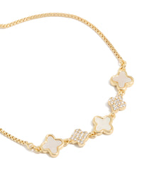 Showcasing a gold plated floral bracelet with cubic zirconia accents and white inlay in a toggle design close up view - link has visual effect only