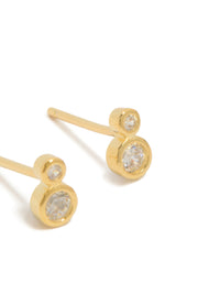 Highlighting dainty stud earrings crafted from gold plated sterling silver with cubic zirconia in a double bezel setting post detail view - link has visual effect only