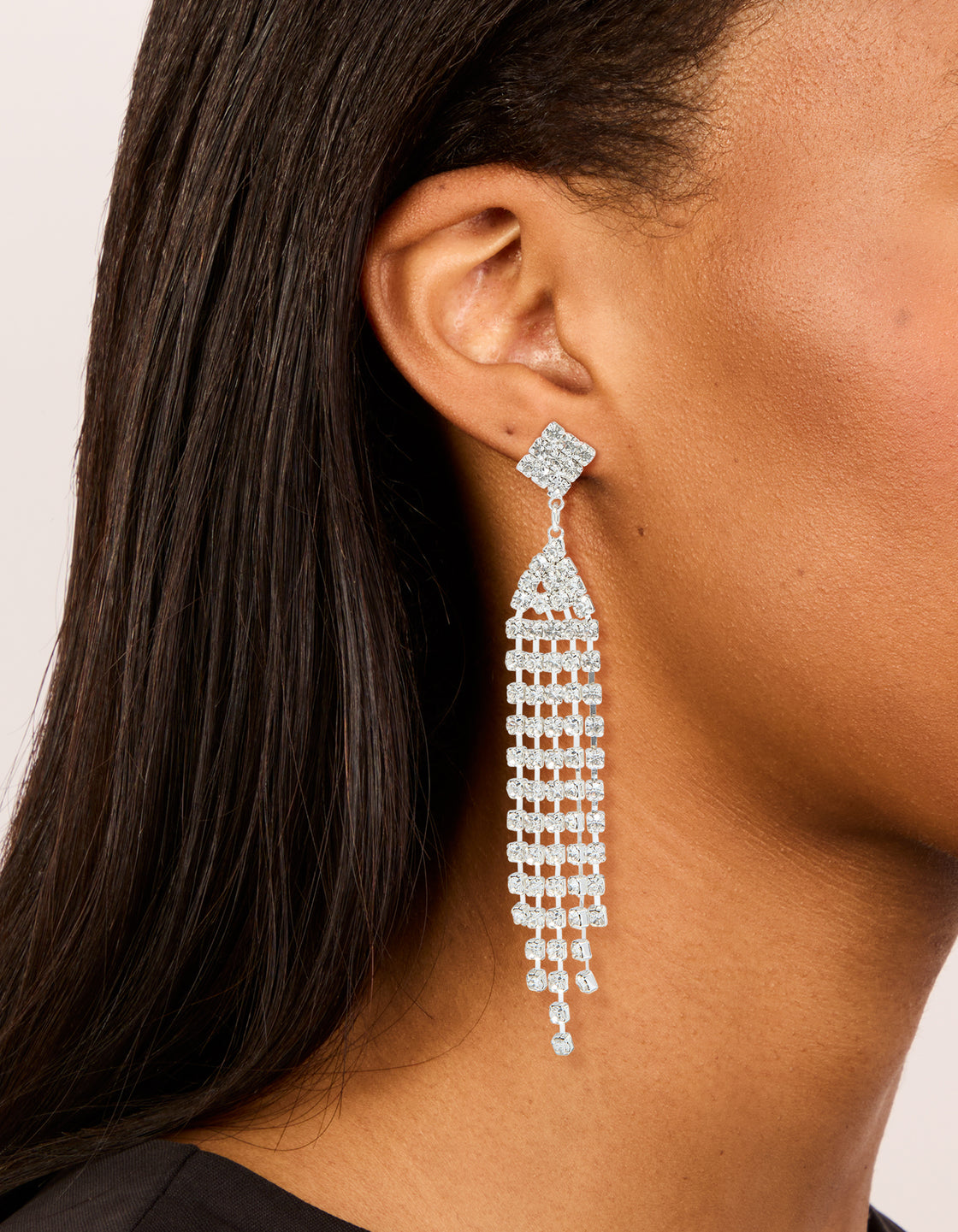 Elegant silver diamante sparkling stud drop earrings with tassel details in clear on ear view