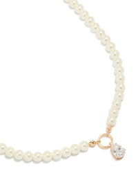 Showcasing a gold cubic zirconia dainty pearl pendant necklace in a close up view - link has visual effect only