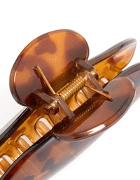 Featuring an arched tortoiseshell claw clip in chocolate sienna and peru shades detail view - link has visual effect only