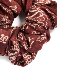 This statement fabric scrunchie showcases paisley design in maroon and beige tones detail view - link has visual effect only