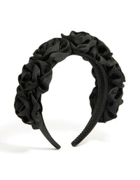 Featuring a black ruched fabric flower headband in statement style front view - link has visual effect only