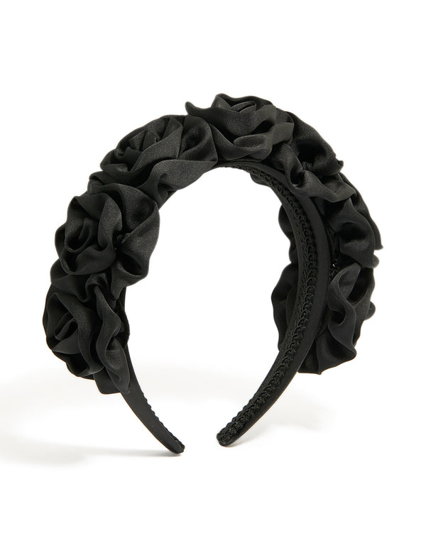 Featuring a black ruched fabric flower headband in statement style front view