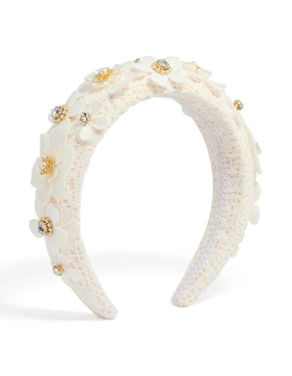 Showcasing a white padded lace headband embellished with floral accents and pearl in ivory, beige, and gold tones front view