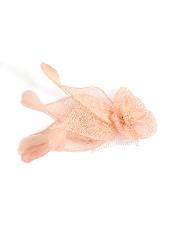 Showcasing a peach pink flower and feather fascinator comb with floral design in solid print front view