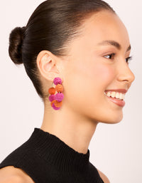 Designed with statement hoop earrings featuring alternating light pink and coral paper-wrapped balls on model view - link has visual effect only
