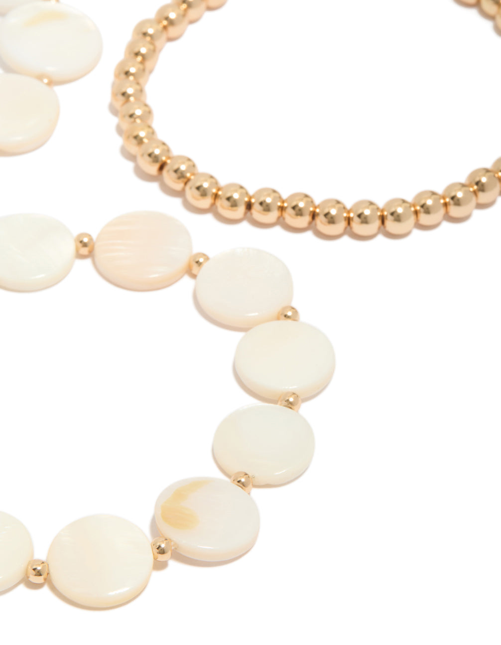 Crafted with gold beads and genuine shell discs in ivory and beige tones, these 4-pack bracelets highlight ocean-inspired design detail view
