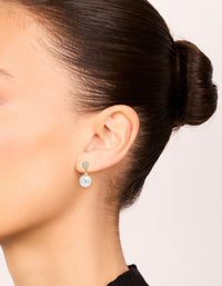 Elegant gold plated small round cubic zirconia and pearl drop earrings in white on ear view - link has visual effect only