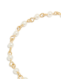 Highlighting the gold plated chain design of pearl and cubic zirconia bracelet featuring celestial star moon charm fob closure detail view - link has visual effect only
