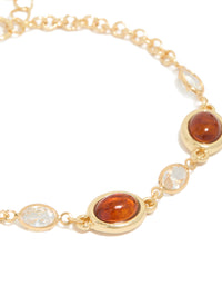 Showcasing a gold plated bracelet with cognac beads and clear cubic zirconia in a tennis style close up view - link has visual effect only