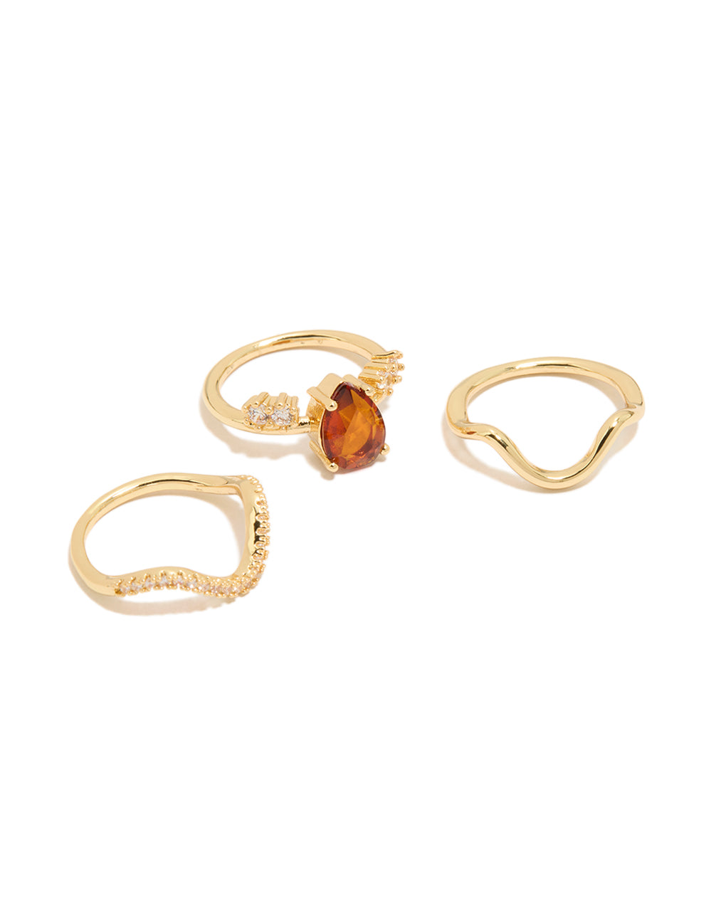 Showcasing gold plated red cubic zirconia teardrop and wavy rings in a statement 3-pack with crystal accents front view