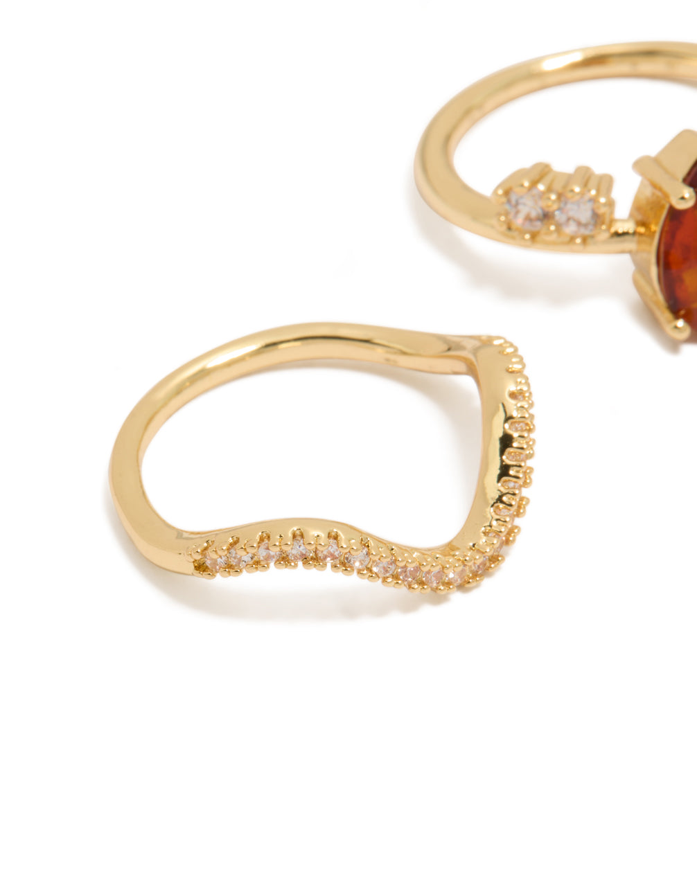 Designed with gold plated red cubic zirconia teardrop and wavy bands, 3-pack statement rings featuring crystal detailing close up view