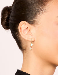 Featuring waterproof gold plated stainless steel forget me not flower drop earrings in white and olive tones on ear view - link has visual effect only