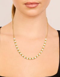 Showcasing alternating balls with pearl accents crafted from waterproof stainless steel in gold plated finish on neck view - link has visual effect only
