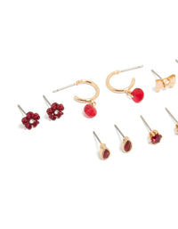 Discover gold red flower and bow earrings 7-pack with floral accents featuring stud and huggie closures in maroon close up view - link has visual effect only