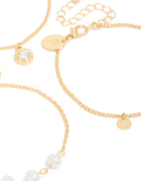 Showcasing a 3-pack of gold charm bracelets accented with pearls, discs, and a solitaire-cut diamante close up view - link has visual effect only
