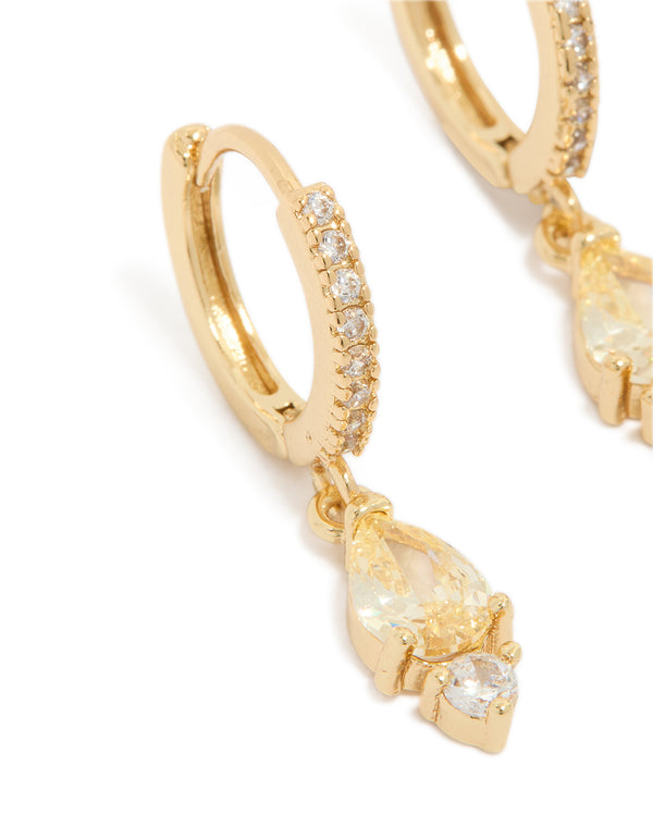 Featuring gold plated cubic zirconia huggie earrings with huggie closure in yellow close up view