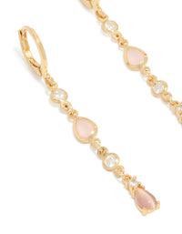 Showcasing gold plated cubic zirconia trio and pink catseye drop huggie earrings close up view - link has visual effect only