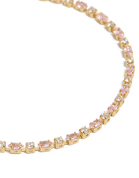 Elegant tennis bracelet crafted from gold plated material with pink and clear cubic zirconia stones close up view - link has visual effect only