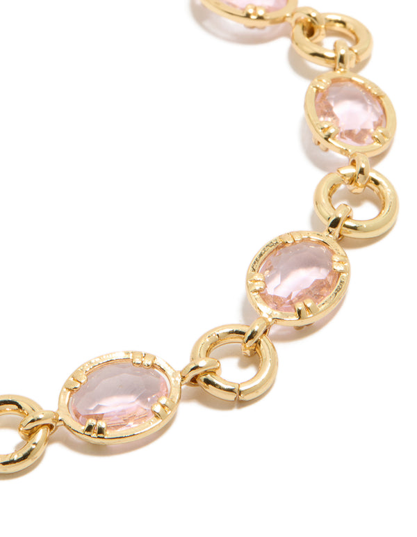Highlighting a gold plated bracelet with large pink cubic zirconia stones close up view