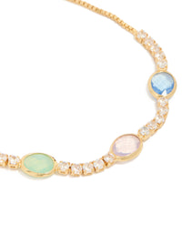 Showcasing bezel toggle bracelet featuring cubic zirconia stones in light sky blue, mint cream and light pink, plated gold, close up view - link has visual effect only